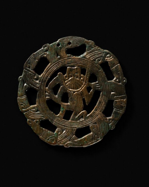 aren im 7. Jahrhundert Bestandteil der Frauentracht und wurden an der linken Körperseite herabhängend, am Gürtel getragen. Solche Gürtelgehänge konnten Werkzeuge, wie Messer oder Kämme, umfassen, aber auch Amulette. Diese Zierscheibe zeigt im Zentrum einen knieenden bärtigen Dämon, der von sieben Tierköpfen umrandet wird. | Fundort: Gammertingen | Landesmuseum Württemberg 